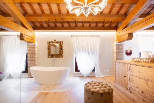 a bathroom with a large tub and a chandelier at Villa Giulia Relais & Spa in Jesolo