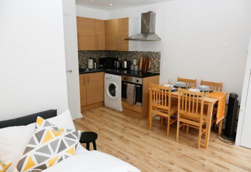 a kitchen and dining room with a table and chairs at New Luxury Apartments in Central London Next to Shops, Cafes, Bars & Metro in London