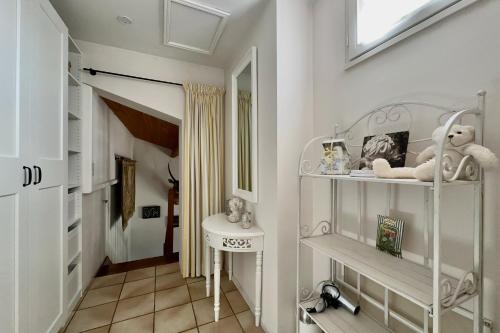 a white hallway with a sink and a mirror at La Terrasse in Douzillac