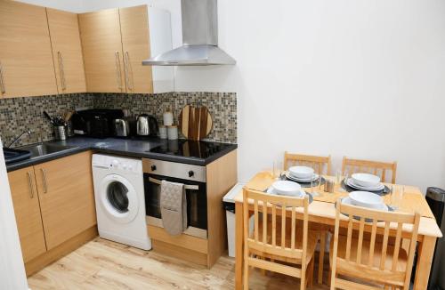 a kitchen with a table and a washing machine at New Luxury Apartments in Central London Next to Shops, Cafes, Bars & Metro in London