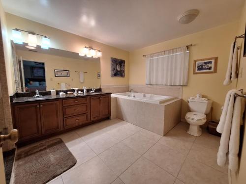 a bathroom with a tub and a toilet and a sink at 3 Bed 2 Bath Amazing Lakeview , Jacuzzi Bath Tub in Oviedo