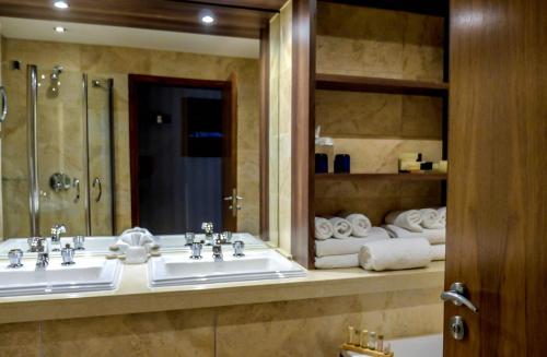a bathroom with two sinks and a mirror and towels at The Big Blue Hotel - Blackpool Pleasure Beach in Blackpool