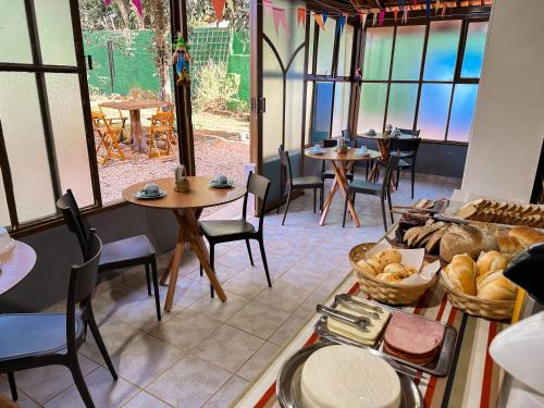 a restaurant with tables and chairs and windows and a table at Pousada das Marias in Alto Paraíso de Goiás