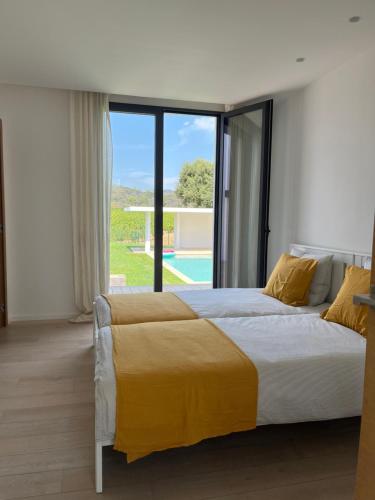 une chambre avec un grand lit et une grande fenêtre dans l'établissement villa au cœur des vignes, à Cogolin