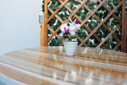 a wooden table with a vase with flowers on it at Beb Cuore del Salento in Merine