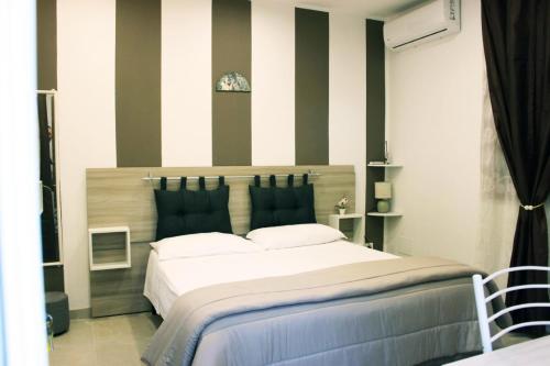 a bedroom with a large bed with striped walls at Beb Cuore del Salento in Merine