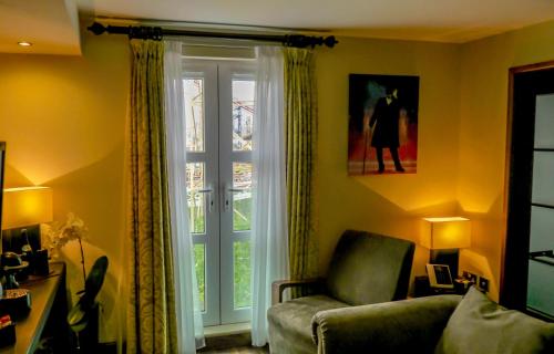 a living room with a chair and a sliding glass door at The Big Blue Hotel - Blackpool Pleasure Beach in Blackpool