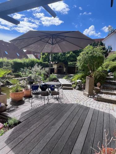 un patio con tavolo, sedie e ombrellone di Ferienoase in der Bierstadt Radeberg bei Dresden a Radeberg