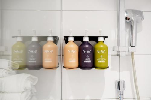 a row of bottles of laundry detergents in a bathroom at Holiday Inn London-Shepperton by IHG in Shepperton