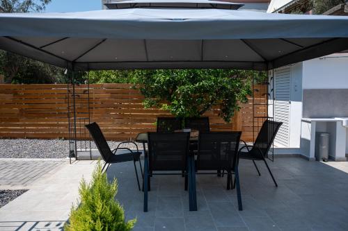 a table and chairs under an umbrella on a patio at Centro Stone House in Tolo