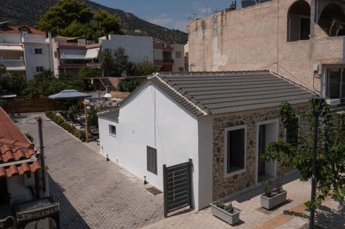 a small white building with a door on a street at Centro Stone House in Tolo