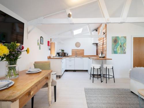 a kitchen and living room with a table and chairs at Bright & Airy Countryside Cabin Near Oxford, Perfect Getaway with Scenic Views - Pass the Keys in Stanton Saint John