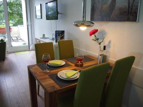 a wooden table with wine glasses and a vase with a flower at Apartment Harzgrün 1 in Sankt Andreasberg