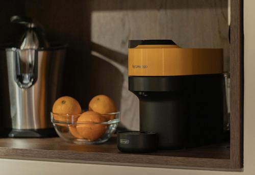 a bowl of oranges on a counter next to a coffee maker at Harmonies BnB in Bari