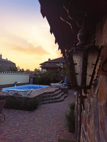 a light on a building with a swimming pool at Guest House Barkhat in Zatoka