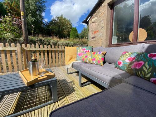 patio con divano, tavolo e recinzione di The Old Post Office, Cosy Cottage in Northumberland, Near Coast, Dog Friendly a Chatton