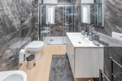 a bathroom with a toilet sink and a shower at Domus Suite Herculaneum jacuzzi in Ercolano