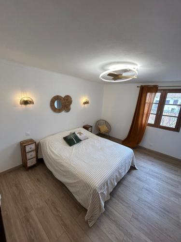 une chambre avec un lit et un ventilateur de plafond dans l'établissement A casa di u Sciroccu, à Monacia-dʼAullène