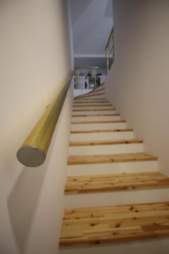 a staircase with wooden floors and a light on the wall at Metaj House in Borsh