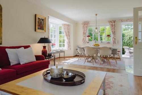a living room with a red couch and a table at Haus Traumzeit Family in Braderup