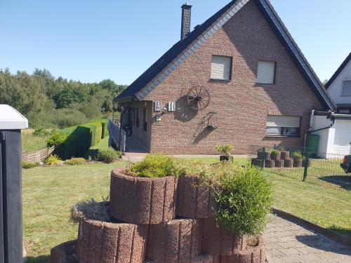 a house with a stack of logs in front of it at FeWo Eifel-Oase mit Garten in Mechernich