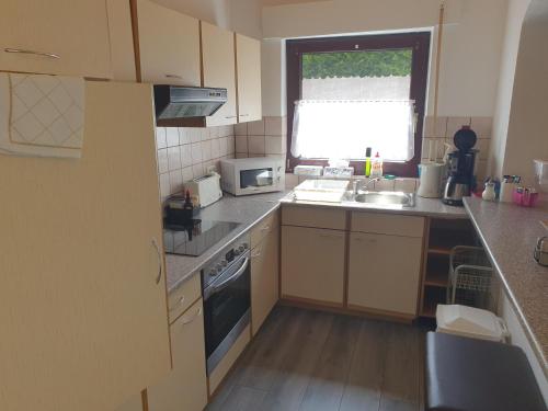 a small kitchen with a sink and a window at FeWo Eifel-Oase mit Garten in Mechernich