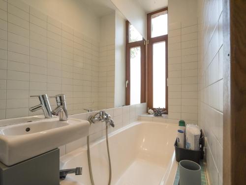 een badkamer met een ligbad en een wastafel bij Midcentury modern, quiet, 40m studio with bath in Rīga