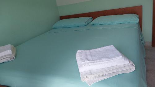 a blue bed with towels on it in a room at Tramonto sul Tirreno in Acquappesa