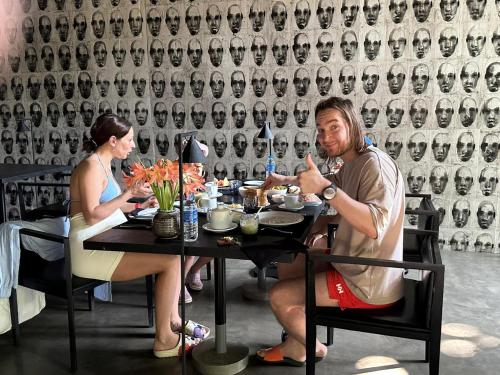 a man and woman sitting at a table in a restaurant at Saffron Robes Living in Hikkaduwa