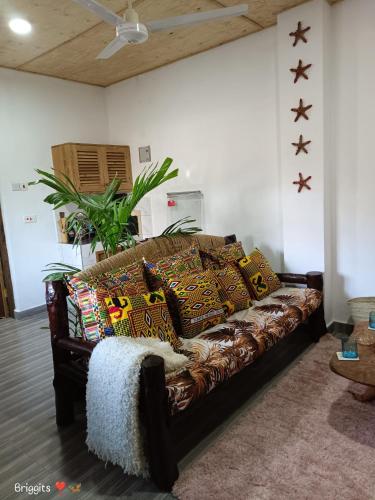 a couch with pillows on it in a living room at Hellenas Gem in Ukunda