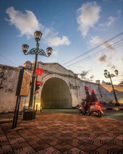 two people riding a scooter in front of a bridge at Sare Living Homestay in Timuran