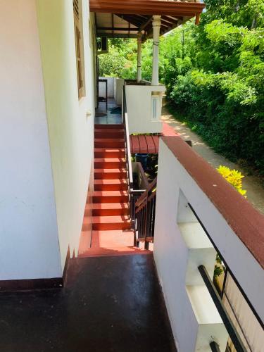 a stairway leading to a house with a porch at Deshan Homestay & Restaurant in Tangalle