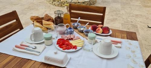 a table with a plate of fruit and bread on it at Les chambres de la Dombes in Pizay