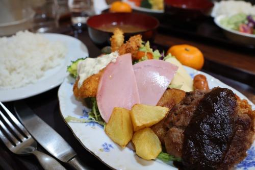 a plate of food with meat and potatoes on a table at Barber HARUNA in Akutsu