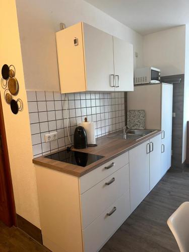 a kitchen with white cabinets and a counter top at Seehaus Mamming - Hotel - Schlaffässer - Biergarten - Camping in Mamming