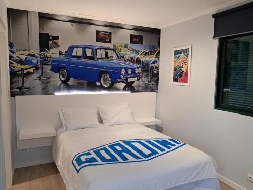 una camera con un letto e una macchina blu appesa al muro di Classic Car House a Santa Cruz