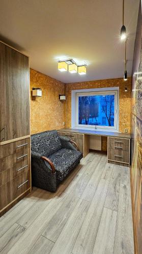 a living room with a couch and a window at SunCity Apartment in Šiauliai