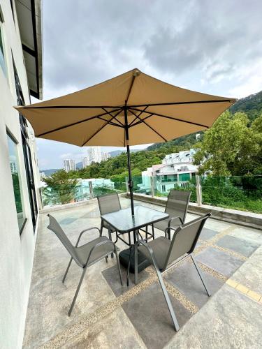 a table and chairs with an umbrella on a patio at Ferringhi Inn 51 in Batu Ferringhi