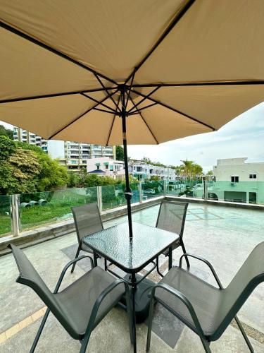 a table and chairs with an umbrella on a patio at Ferringhi Inn 51 in Batu Ferringhi