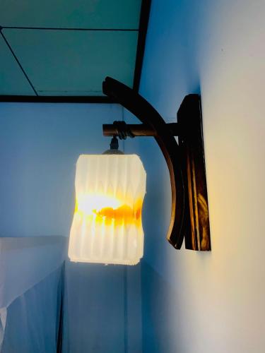 a light that is hanging on a wall at Deshan Homestay & Restaurant in Tangalle