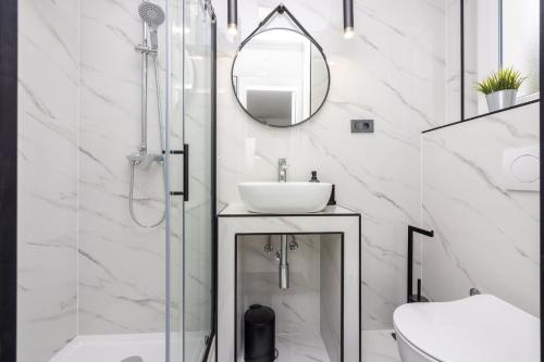 a bathroom with a sink and a shower with a mirror at Villa Ketty in Baška