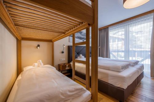 a bedroom with two bunk beds and a window at Wildkogel Resorts - DAS Bramberg in Bramberg am Wildkogel