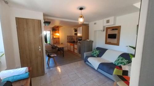 un salon avec un canapé et une cuisine dans l'établissement La Maison des Prés Disney Paris, à Chambry