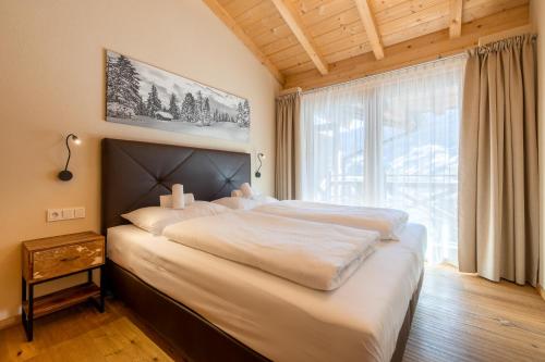 a large bed in a room with a large window at Wildkogel Resorts - DAS Bramberg in Bramberg am Wildkogel