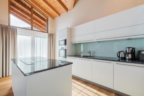a kitchen with white cabinets and a counter top at Wildkogel Resorts - DAS Bramberg in Bramberg am Wildkogel