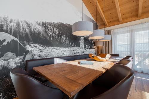 a dining room with a wooden table and leather chairs at Wildkogel Resorts - DAS Bramberg in Bramberg am Wildkogel