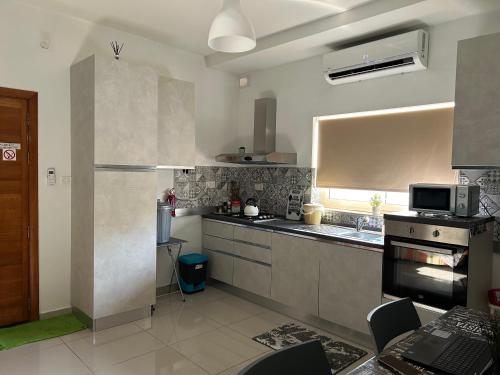 a large kitchen with a sink and a refrigerator at Centrally located one floor in Paola