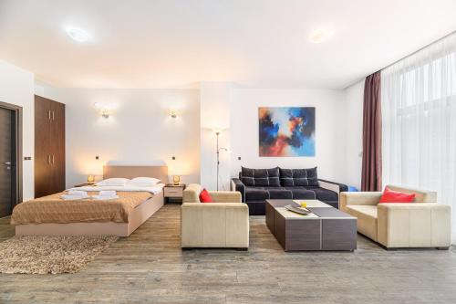 a bedroom with a bed and a living room with a couch at Alpine Escape Studio - Silver Mountain Resort & SPA - Poiana Brasov in Poiana Brasov