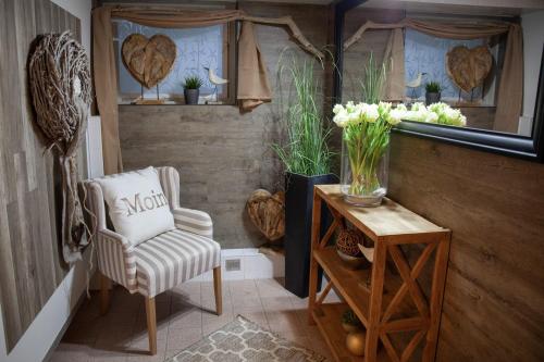 a room with a chair and a table with flowers at Seehaus Mamming - Hotel - Schlaffässer - Biergarten - Camping in Mamming