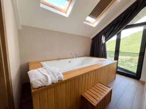 a bathroom with a large bath tub with a window at Ladur Resort Otel in Trabzon